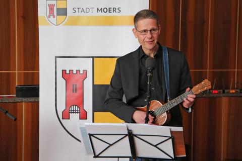 Christian Behrens vom niederrheinischen Kleinkunsttheater ‚Kleine Welten‘ mit einer Gitarre