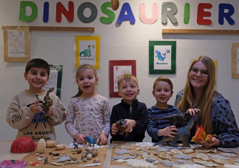 Mehrere kleine Kinder, die Dinosaurier ausstellen 