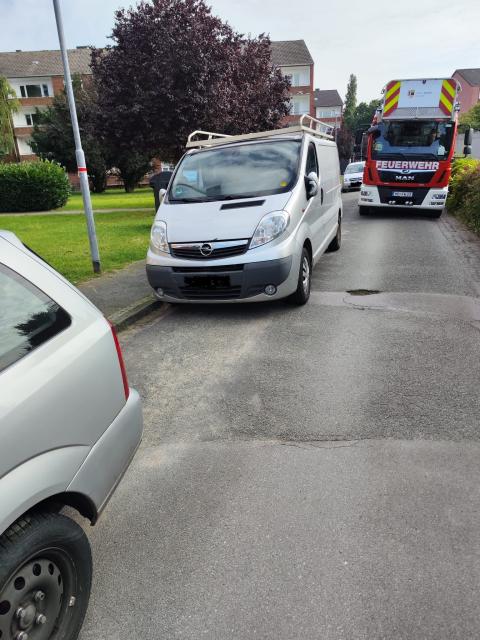 Ein Feuerwehrauto kommt in einer Straße nicht an einem Auto vorbei.