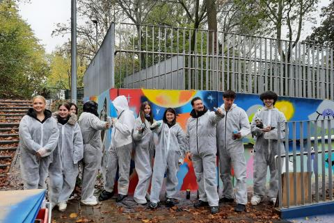 Schülerinnen und Schüler arbeiten an Graffitis.