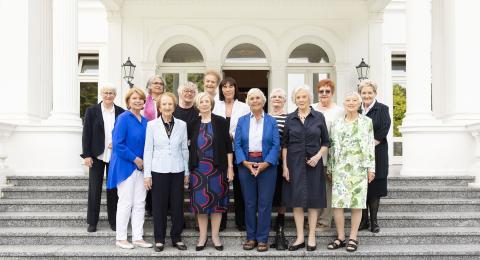 Eine Gruppe von Frauen vor einem Gebäude.